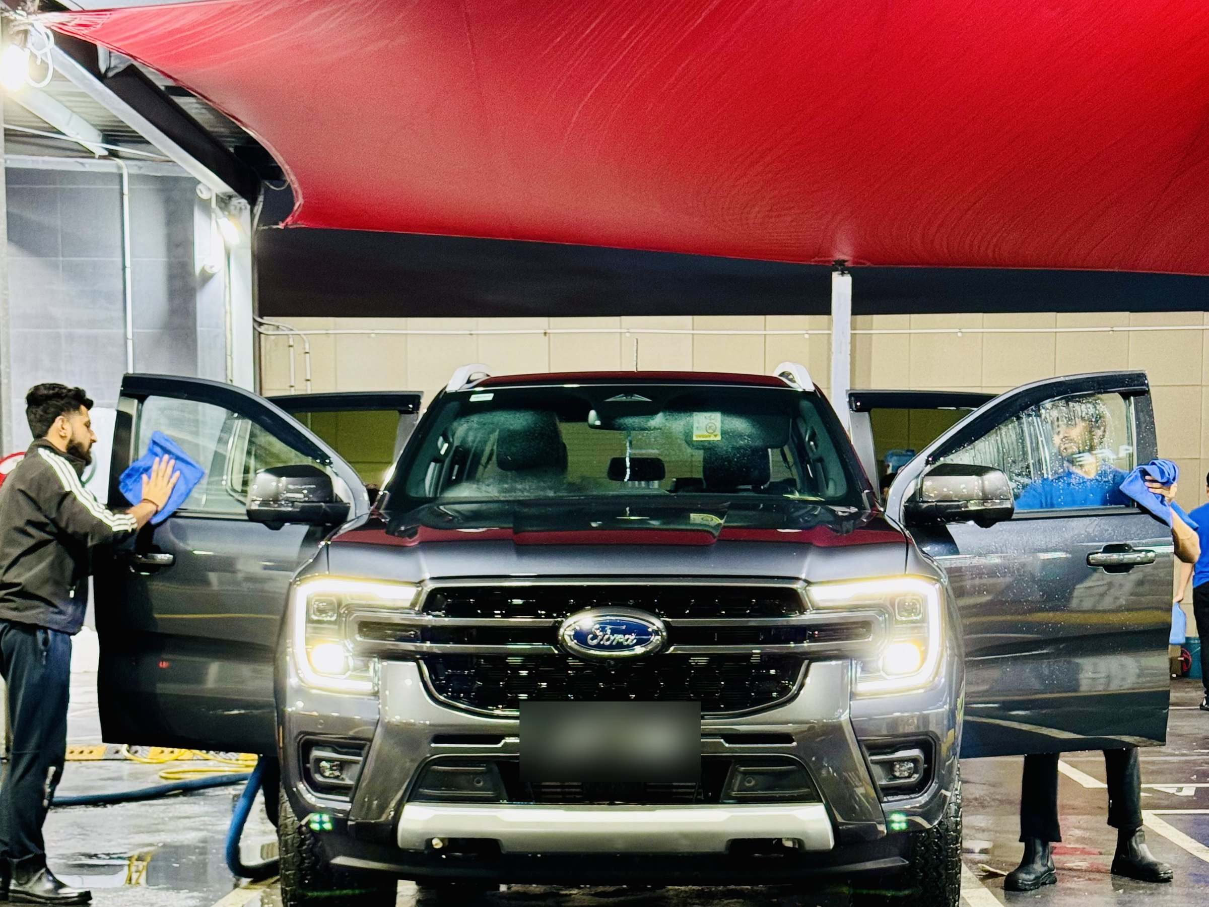 Our team cleaning a Ford Everest inside and out under the red canopy at White Diamond Belmore