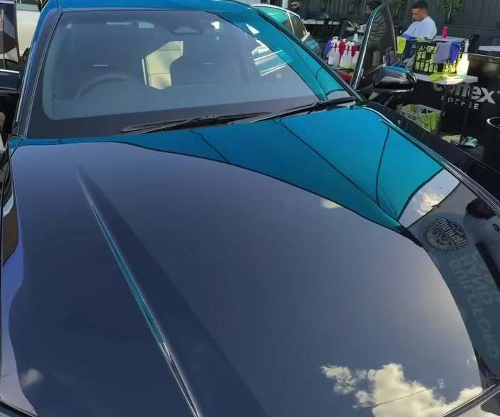 Glossy black bonnet reflecting the sky after a wash and hand polish